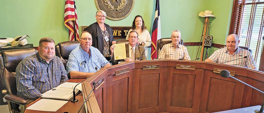Trinity County Commissioners (from left) Tommy Park, Neal Smith, Judge Doug Page, Mike Loftin and Steven Truss stand with Renee Murphy and Rana Wingo of the SAAFE House after the county proclaimed April as Child Abuse Prevention Month. Photo by Tony Farkas
