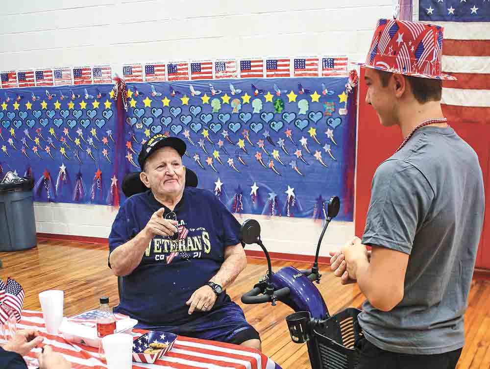 A Groveton student talks with a group of veterans. Photo by Tony Farkas