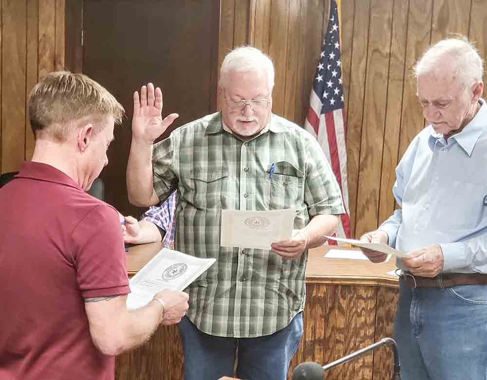 Newly elected Trinity City Council Member Bryan Buck, along with Mayor Pro Tem Phillip Morrison, take the oath of office administered by Mayor Billy Goodin. The two men won in the May 6 city election. PHOTO BY TONY FARKAS