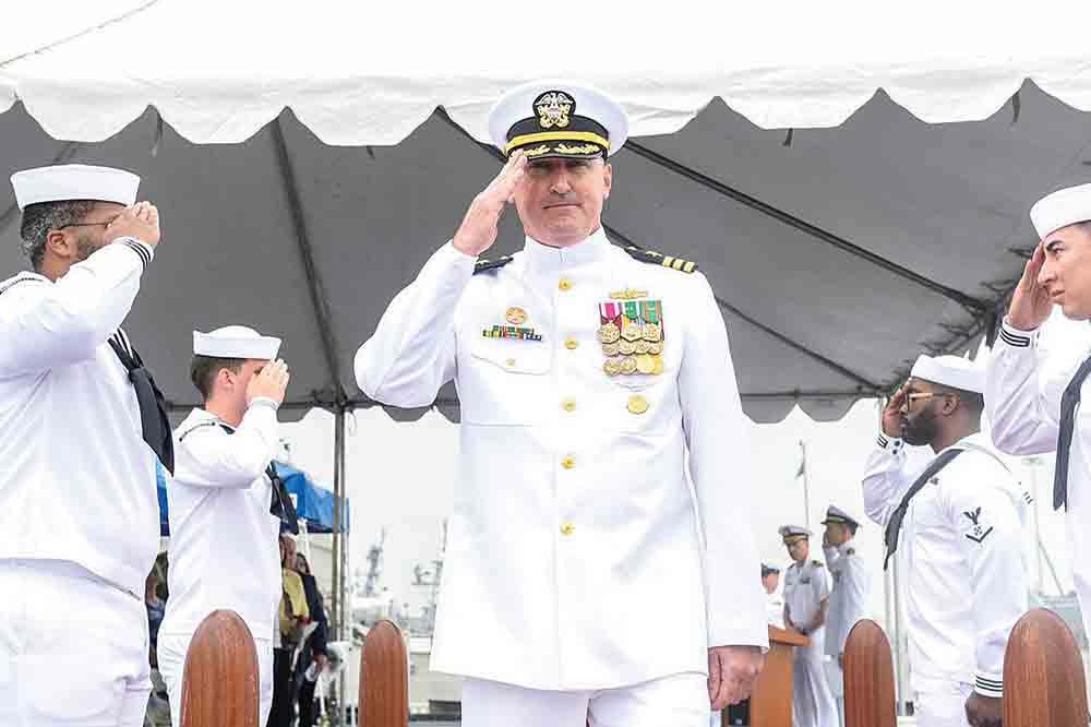 Woodlake native Cmdr. William Ashley, commanding officer of Independence-variant littoral combat ship USS Canberra Blue crew, salutes sideboys during a change of command ceremony on Canberra’s flight deck on May 19. U.S. Navy photo by Mass Communication Specialist 1st Class Vance Hand