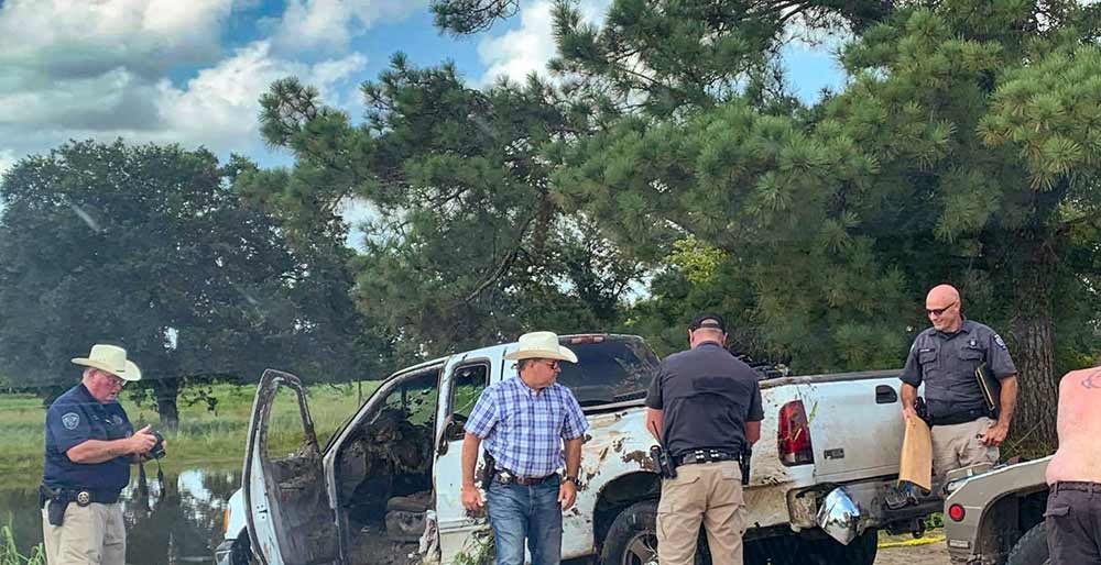 Trinity County Sheriff’s Office deputies examine a vehicle that was pulled from a private lake at the scene where two men were found dead. (Courtesy Photo)
