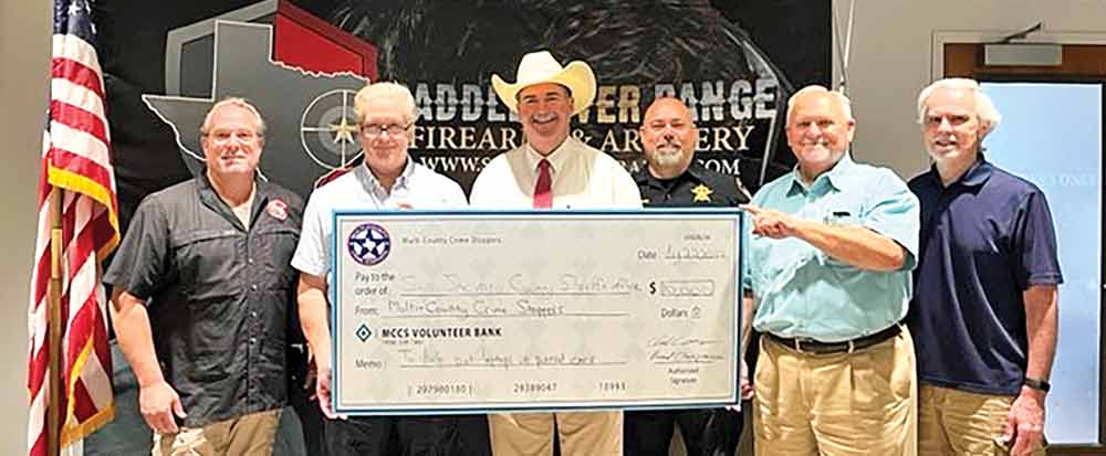 Thom Bolsch (from left) of Saddle River Ranch, Charles Costenbader, Chairman of Crime Stoppers, Sheriff Greg Capers, Steve Squier, MCSO, Ronnie Rector, MCSO, and Warren Cherry of Crime Stoppers display the $10,000 donation given to the sheriff's office. Courtesy photo