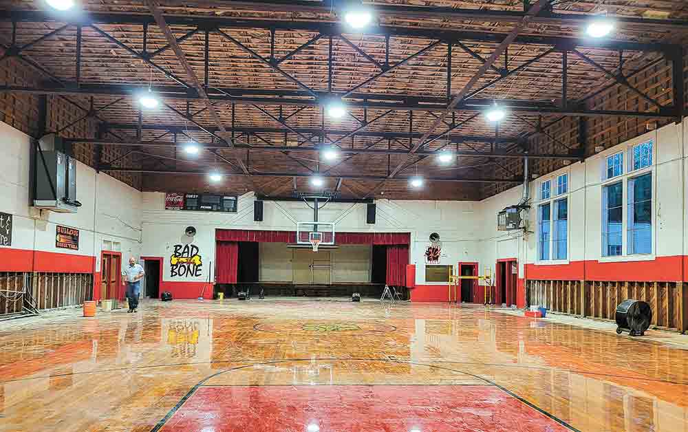 (Right) The roofing material of the gymnasium at Centerville school was blown off during an August thunderstorm. (Left) The interior of the Centerville gym was made mostly of wood, including the stage, the floor and the bleachers, all of which were damaged after a storm removed the roofing material. Photo by Tony Farkas