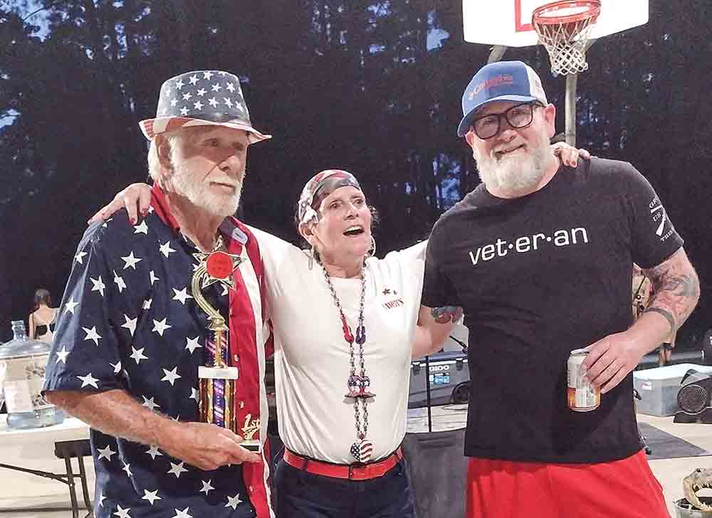 Winner of the adult patriotic dress competition with his trophy and friends. (Left) Winner of the pet patriotic dress contest with his owner. 