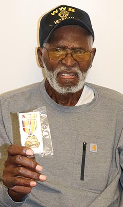Alonzo Randolph holds up a medal given to him to commemorate his service in the Burma campaign in WWII. Receiving the medal was an emotional moment for the combat veteran, who received it on his 102nd birthday.  CHRIS EDWARDS | TCB FILE PHOTO