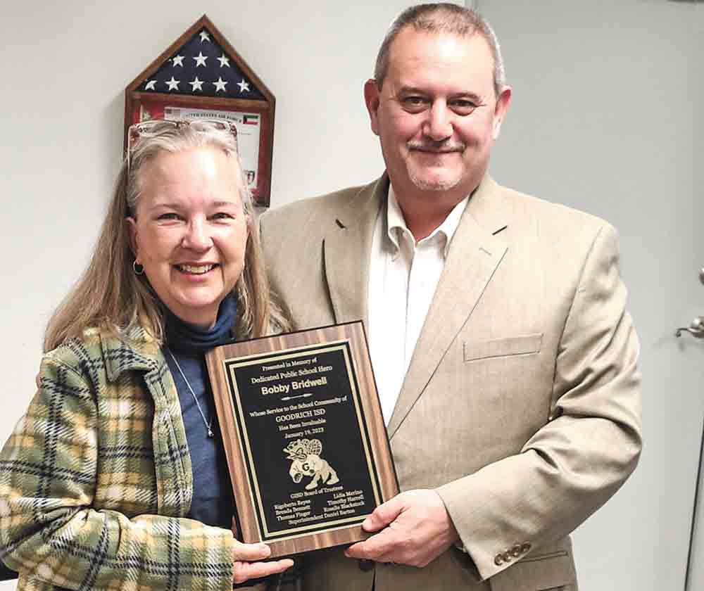 Julie Mack accepts a plaque in honor of her husband,Bobby Bridwell, who died a few months ago while serving on the board. The plaque reads, “Presented in memory of dedicated public school hero Bobby Bridwell whose service to the school community of Goodrich ISD has been invaluable.” Mack is pictured with Goodrich Superintendent Daniel Barton. Photo by Brian Besch