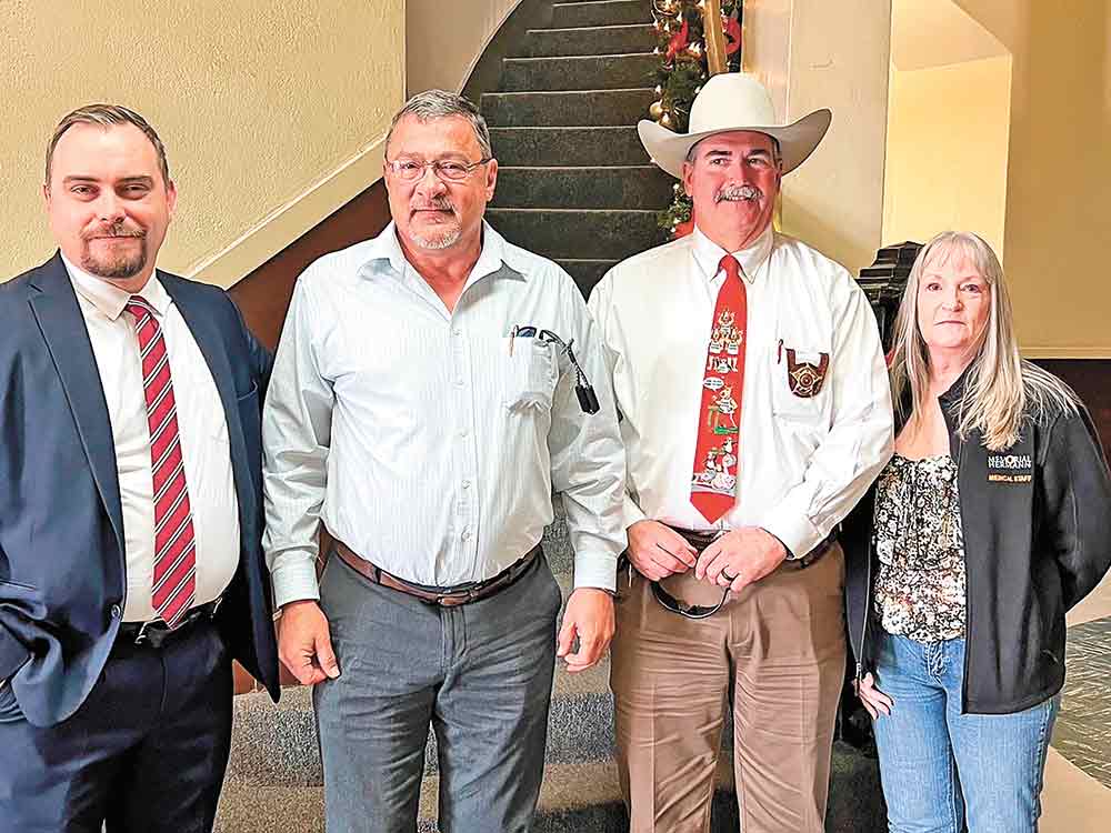Todd Dillon (left), Assistant District Attorney, stands with David Pfluger, Sheriff Greg Capers and  Penny McElhaney, during a ceremony that proclaimed Dec. 21, 2021, as Deputy Bryan Pfluger Day in San Jacinto County. Courtesy photo