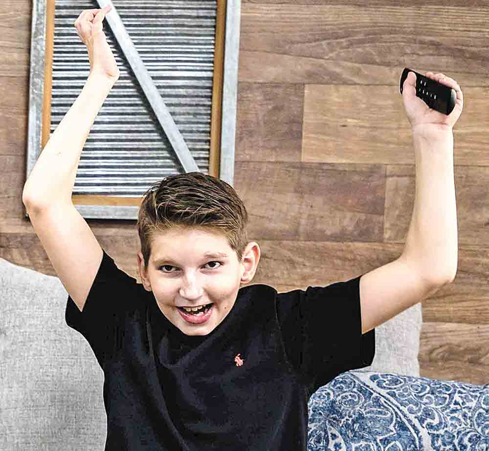 JUMPING FOR JOY  Hayden Thiel, a nonverbal autistic young man, is thrilled to no longer be losing the remote control following his mother’s invention of The Remote Retriever, an electronic accessory that helps find lost or misplaced remote controls. Courtesy photo