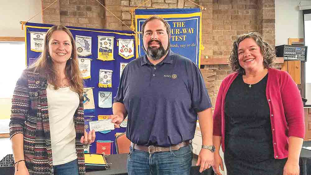 Kari Miller and Jenn Thompson, who are affiliated with Polk County Recycling & Beautification, accept a donation from Andrew Boyce, president of the Rotary Club of Livingston, following a recent presentation of PCRB’s local recycling efforts.  Photo by Emily Banks Wooten