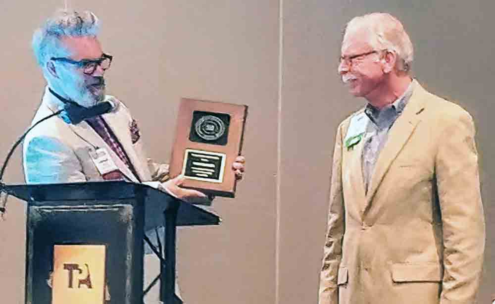 Leonard Woolsey, outgoing president of the Texas Press Association, presents a Golden 50 Award to Donnis Baggett in recognition of 50 years of service to journalism. Baggett was born and reared in Livingston. Photo by Emily Banks Wooten