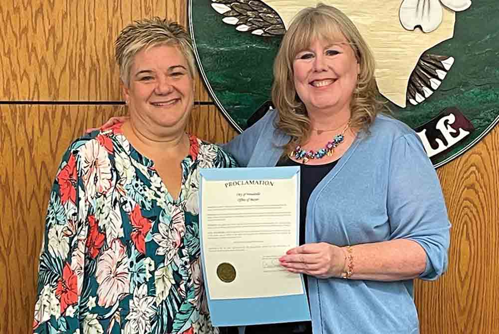 Woodville City Administrator Mandy Risinger receives a proclamation from Mayor Amy Bythewood honoring her spotlight as the county’s “Best Public Servant” by popular vote in the Tyler County Booster’s “Best of” contest. MOLLIE LASALLE | TCB