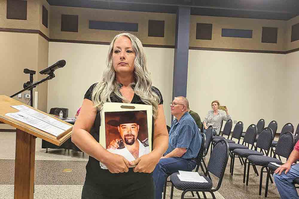 Jenifer Jones displays a picture of her brother who was murdered, and accused the Sheriff’s Office of ignoring the case. Photo by Tony Farkas