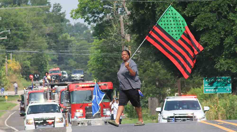 Cindy Williams crosses in front of the annual Trinity Juneteenth parade on Saturday carrying the Juneteenth flag.PHOTO BY TONY FARKAS