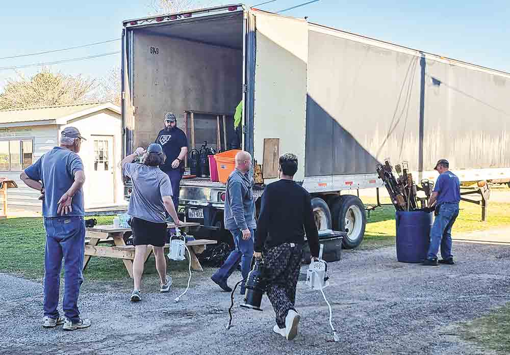 Volunteers with First Baptist Church unload one of two tractor-trailers at Pedigo Park Monday to begin the process of building Bethlehem. Photo by Brian Besch