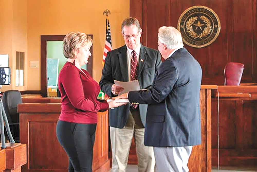Outgoing County Judge Doug Page swears in new Judge Danny Martin at an event on Sunday. COURTESY PHOTO