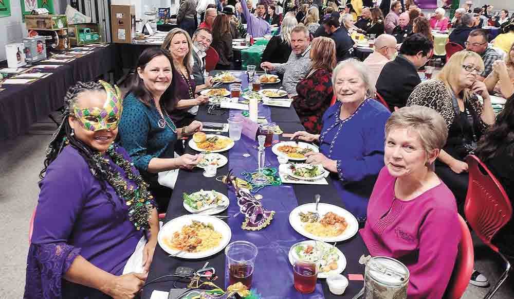 Chamber President Barbara Justice (left) sets the tone for the Mardi Gras-themed event. Courtesy photo