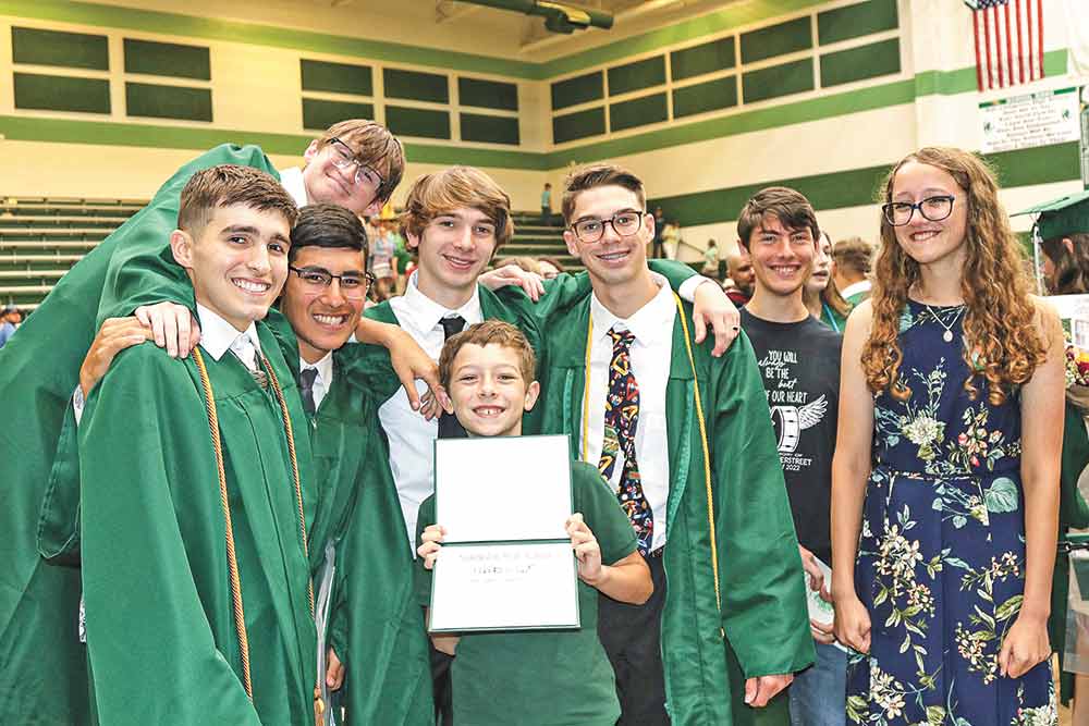 Ben Overstreet, younger brother of Cole, holds up the diploma, surrounded by friends and his sister.