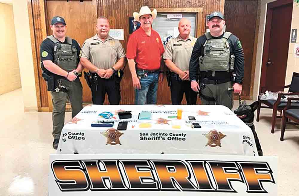 San Jacinto County Deputy Jared Oliver, Sgt. Mark Gustafson, Sheriff Greg Capers, Patrol Division Lt. Ray Bowen, K9 Handler Deputy Dustin Oliphant with K9 Lady Duna display a small sampling of the seized drugs and paraphernalia from a recent drug arrest in Cleveland. Courtesy photo   
