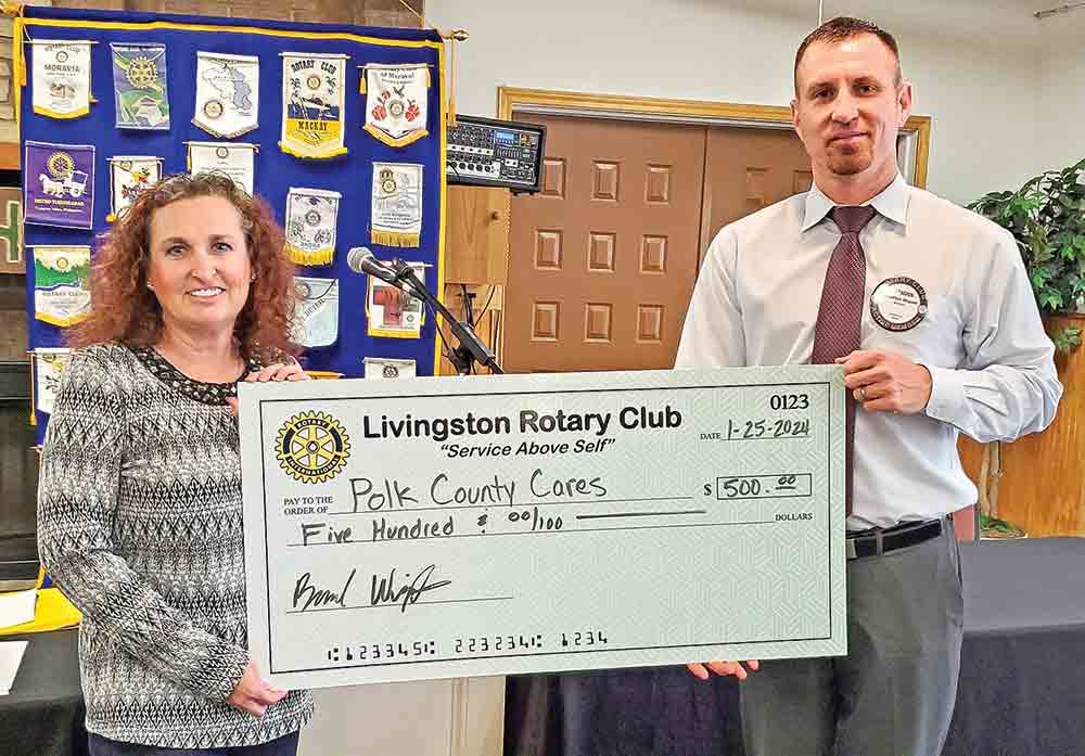 Brandon Wigent, president of the Rotary Club of Livingston, presents a check to Toni Cochran-Hughes, who is receiving it on behalf of Polk County Cares, a 501(c)3 non-profit organization that raises funds to be distributed to qualifying non-profit organizations in Polk County.  Courtesy photo
