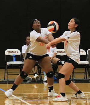 Trinity Lady Tigers Destinee Simmons (No. 12) and Vanessa Acosta both look to return a serve during an Aug. 31 match against Apple Springs.