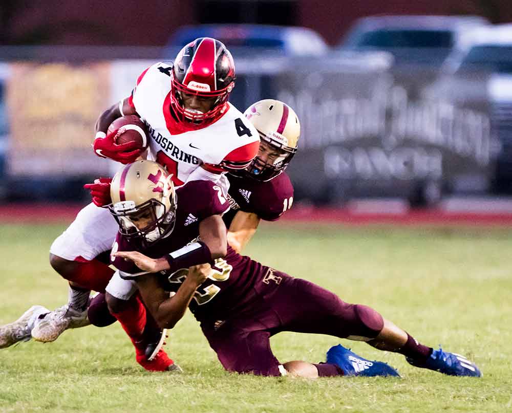 Cam Shaw-Rucker (No. 4) slides off tackle for a nice yardage gain during the Friday night’s game against The Tarkington Longhorns, with a 51-0 win. (Photo by Charles Ballard.)