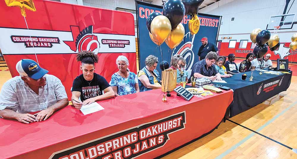 From left, Coldspring-Oakhurst High School seniors Eddy Brown, Hayden Richardson and K.D. Bookman were surrounded by their families as they signed Letters of Intent on Tuesday, April 5.