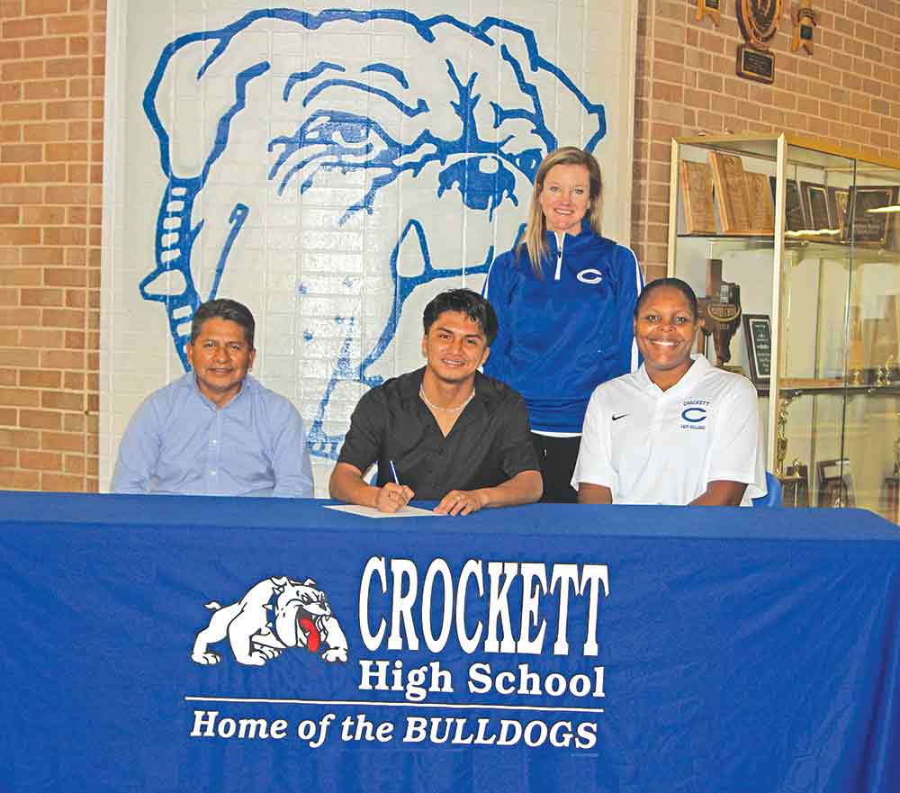 Omar Garcia signs a letter of intent with Jacksonville College for cross-country, track and soccer during a ceremony in the Crockett High School foyer last Wednesday. He is pictured with his father, Hipolito Garcia (left), CHS cross-country coach Jordan Heersink (standing) and coach TaNesiah Johnson. LARRY LAMB | HCC
