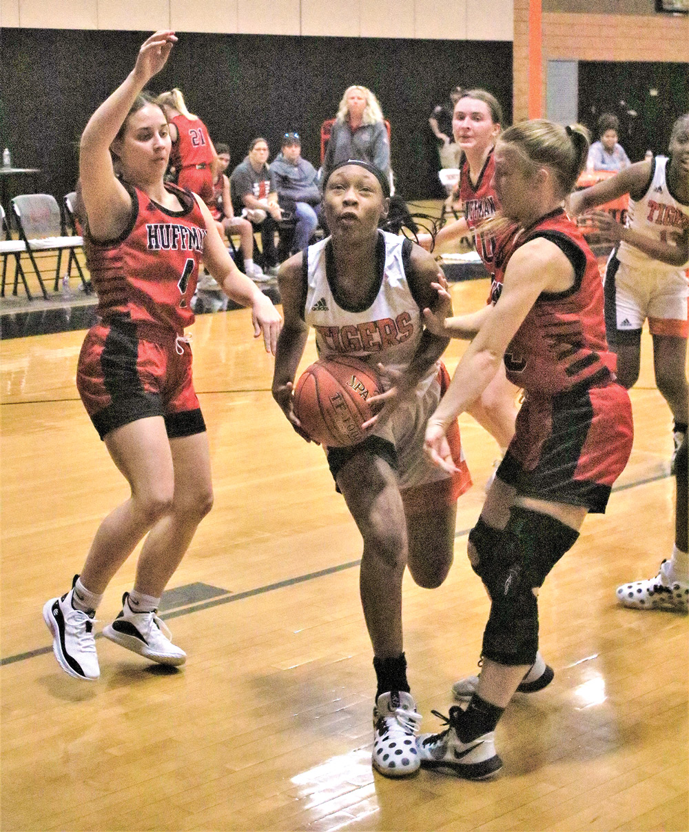 Lady Tiger Tameya Maxie (No. 11) splits two Hargrave defenders for a shot during Friday’s game.  Photo by Tony Farkas/TCNS