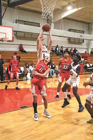 Trojan Cayden Barton pulls down a board during the 86-22 home win over Groveton on Nov. 23. Photo by Tony Farkas