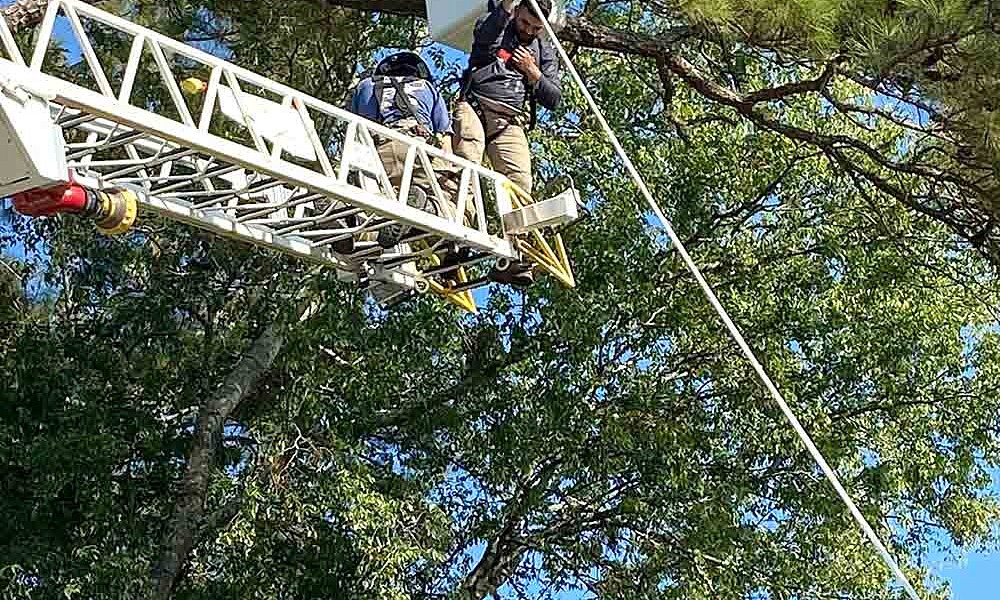 Apple Springs VFD firefighters assist a worker who was hanging from a bucket truck. Courtesy photo